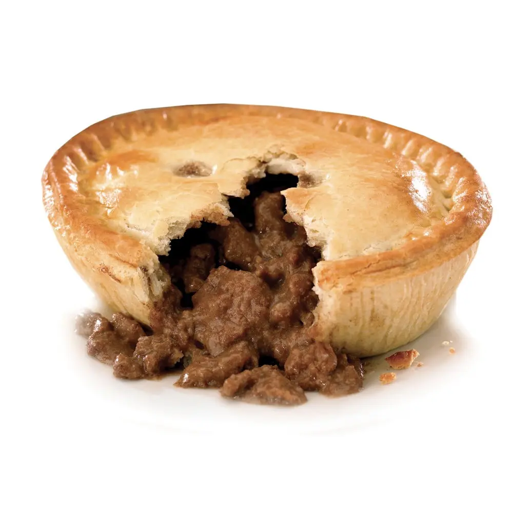 freshly baked steak and kidney pie with the filling oozing out in the centre