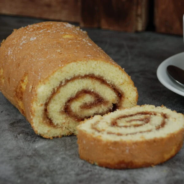 jam swiss roll next to a cup of coffee