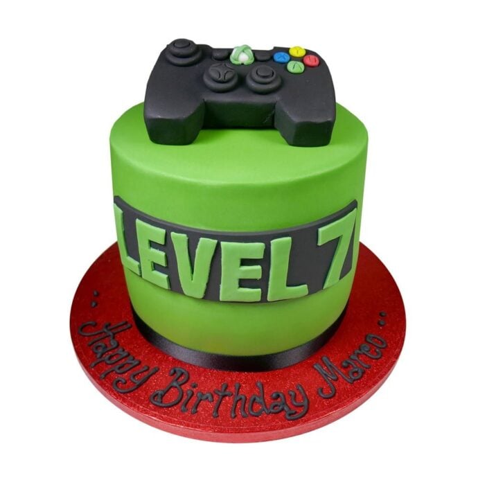green gamer celebration cake with a black Xbox controller made from sugar paste