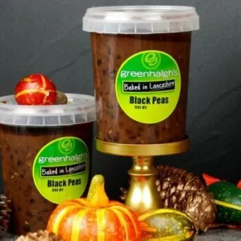 Two tubs of Greenhalgh's Baked in Lancashire Black Peas, 500ml, styled with pumpkins, gourds and pine cones
